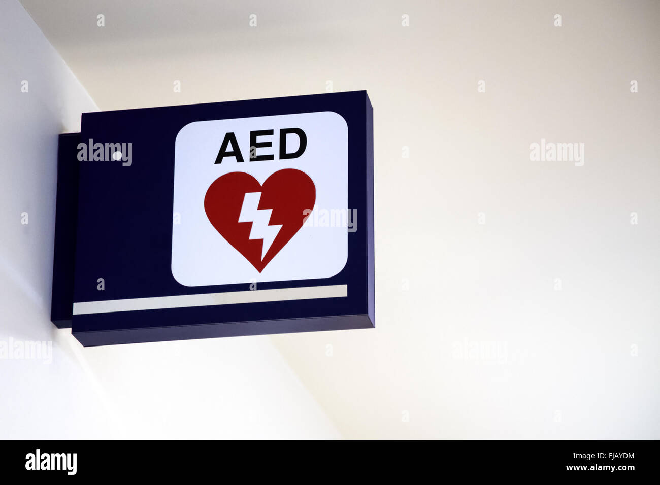 Defibrillatore semiautomatico AED segno su una parete in un aeroporto. Foto Stock
