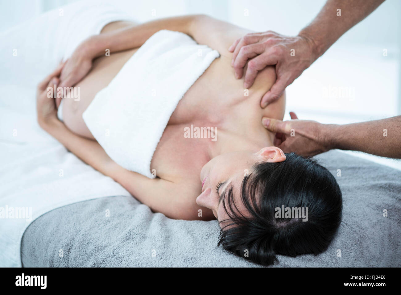 Donna incinta ricevere un massaggio alla schiena da massaggiatore Foto Stock