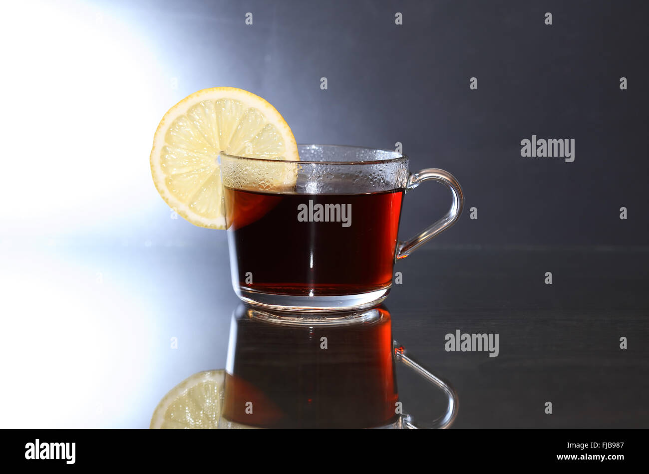 Tazza di tè nero con limone sul bello sfondo scuro Foto Stock