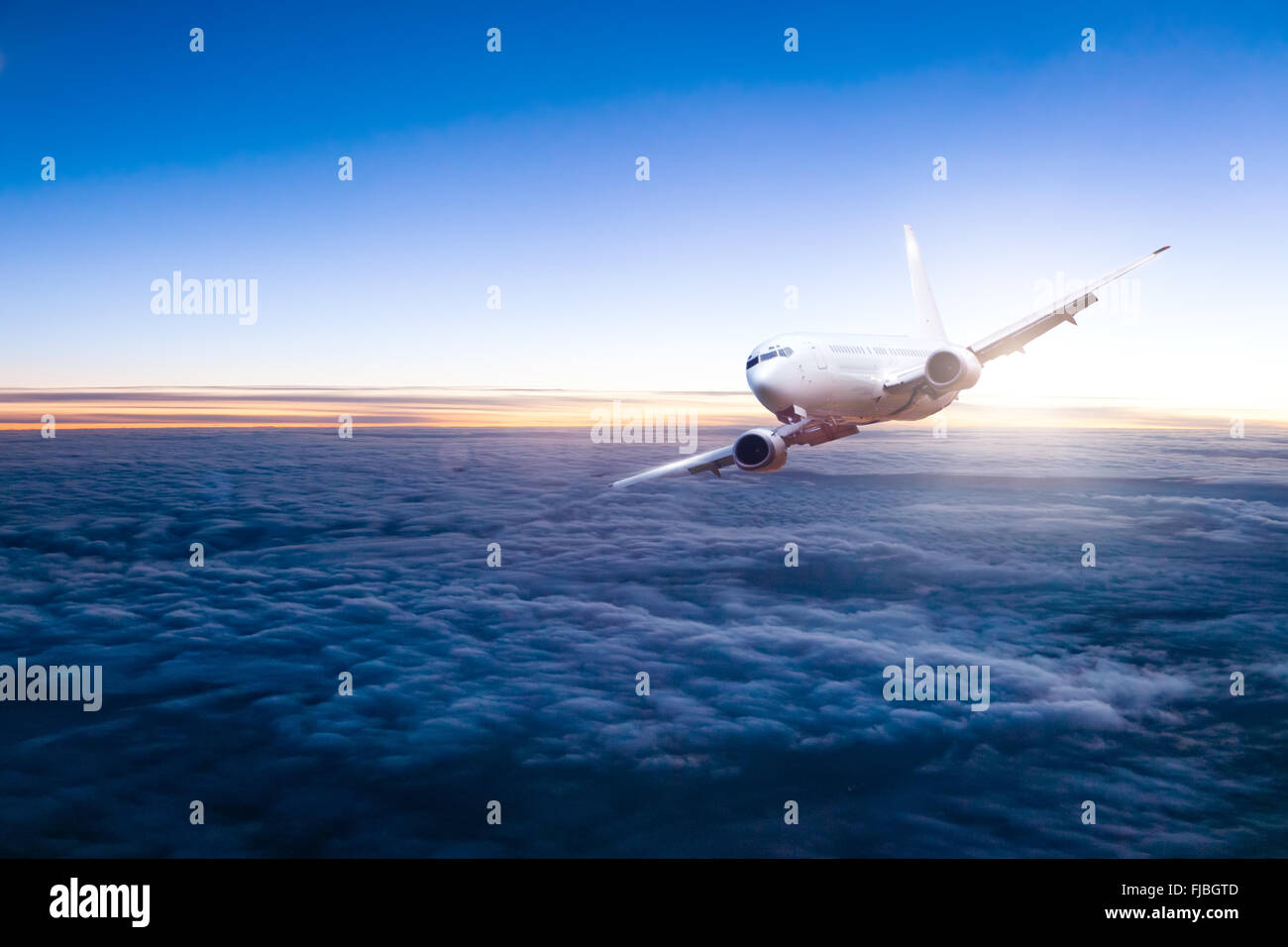 Aviogetti aereo volare sopra le nuvole in bellissimo tramonto scuro Foto Stock