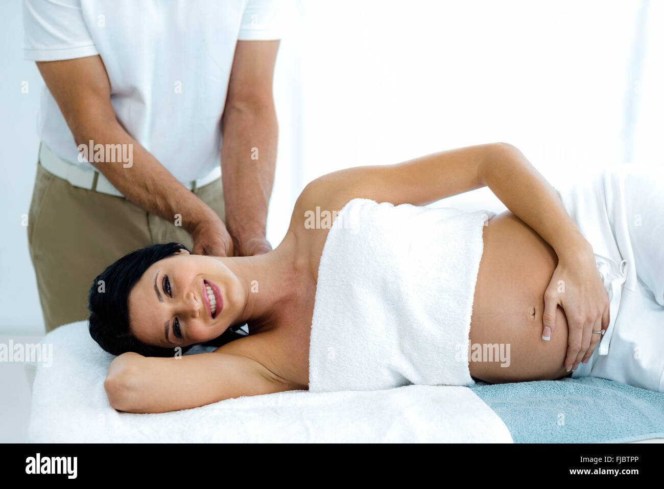 Donna incinta ricevere un massaggio alla schiena da massaggiatore Foto Stock