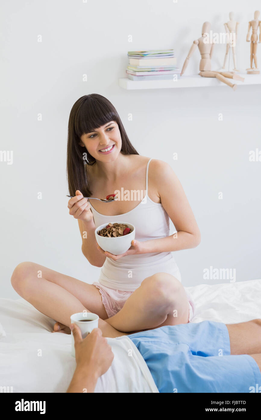 Coppia giovane avente la colazione sul letto Foto Stock