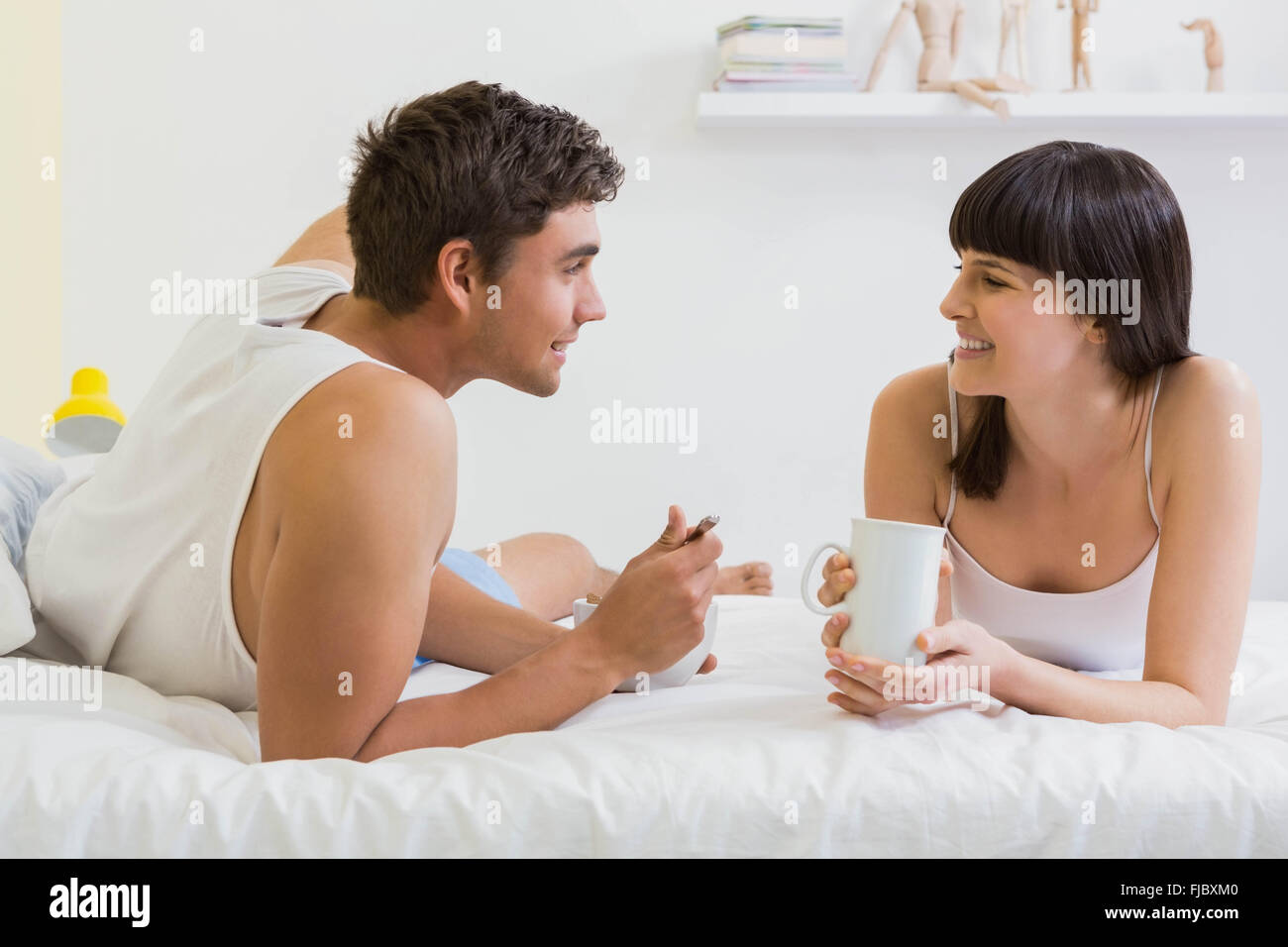 Coppia giovane avente la colazione sul letto Foto Stock