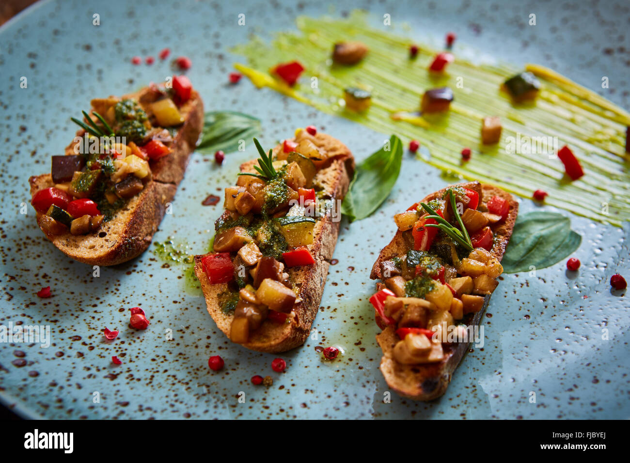 Cibo vegan: bruschetta con peperone, pomodori, rucola, il timo e le foglie di basilico Foto Stock