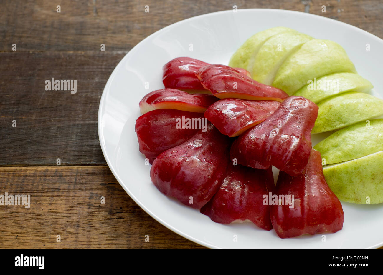 Fetta rosa mela guava e sulla tavola di legno Foto Stock