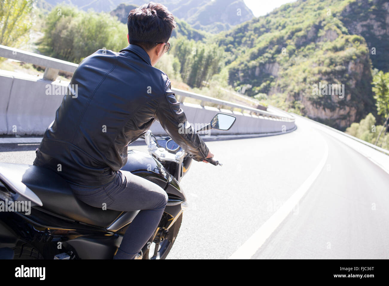 Giovane uomo cinese riding motociclo Foto Stock