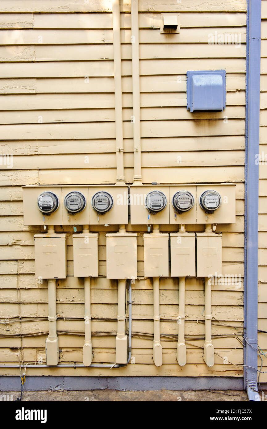 Contatori elettrici sul lato della vecchia casa Foto Stock