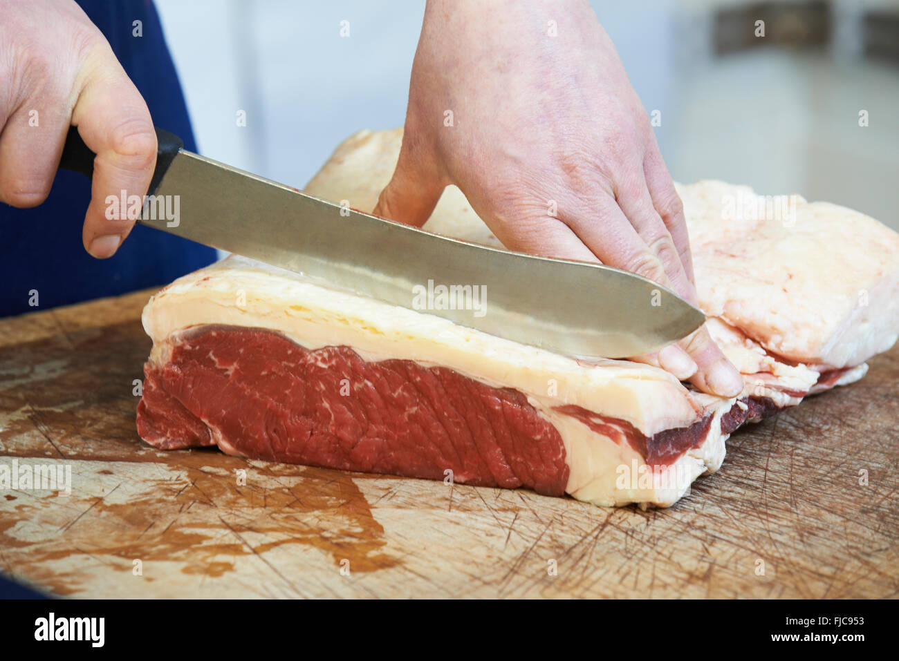 Chiusura del macellaio Preparazione Bistecca di controfiletto Foto Stock