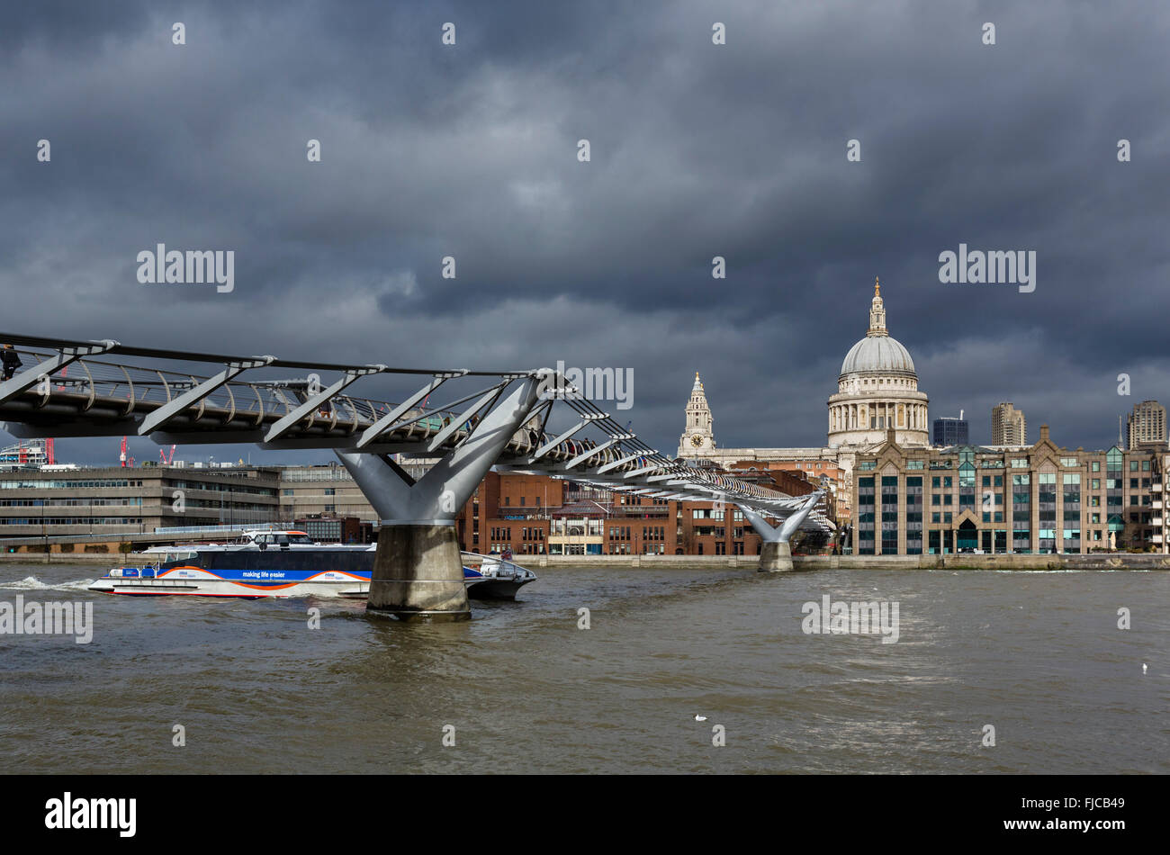 Thames Clipper andando sotto il Millennium Bridge sul fiume Tamigi con la Cattedrale di St Paul e la città dietro, London, Regno Unito Foto Stock