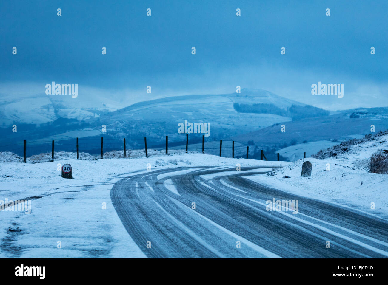 Treacherous le condizioni di guida su una strada ghiacciata dal bordo Stanage nel Peak District. Inverno nel Derbyshire, Inghilterra, 2016. Foto Stock