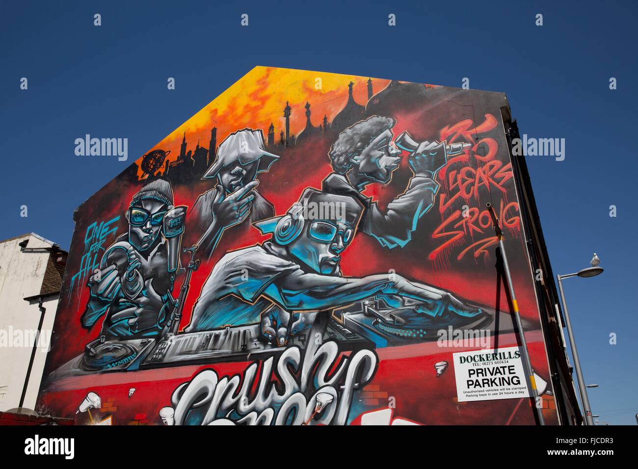 Un graffiti di un DJ riproduzione di musica verniciato a spruzzo su una parete rosa Foto Stock