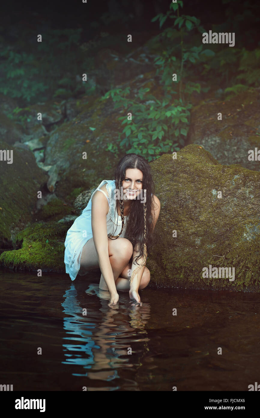 Sorridente donna felice nel flusso delle acque. Ritratto naturale Foto Stock