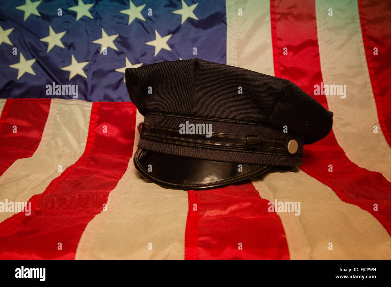 Un cappello di polizia su una bandiera americana sfondo. Foto Stock