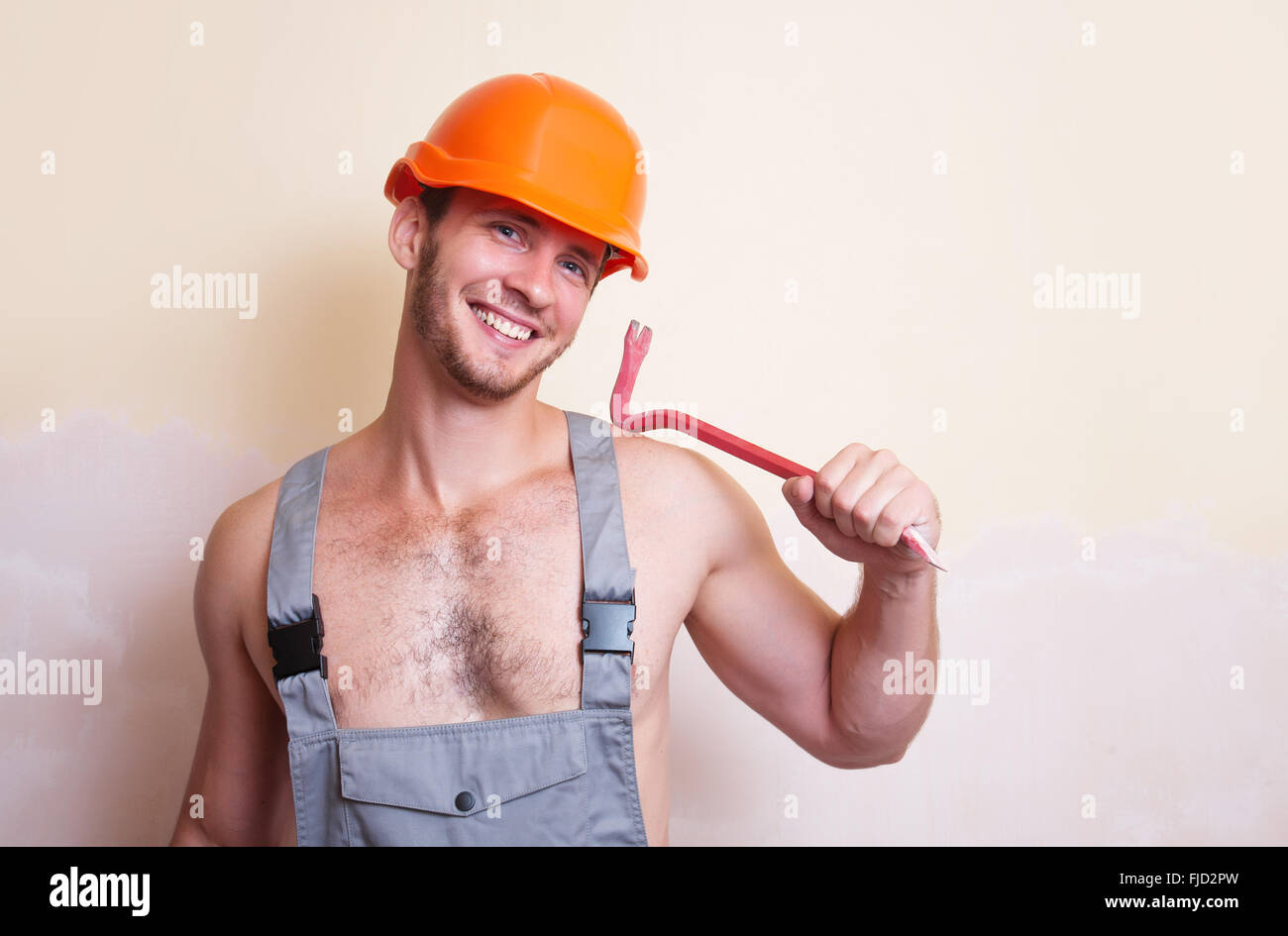 Un uomo in tuta e casco con un utensile per lo smontaggio Foto Stock