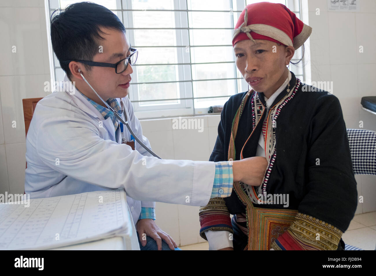 Un medico esamina una donna dalla tribù Dzao presso il divieto Khoang può Ho ospedale nel nord del Vietnam Foto Stock
