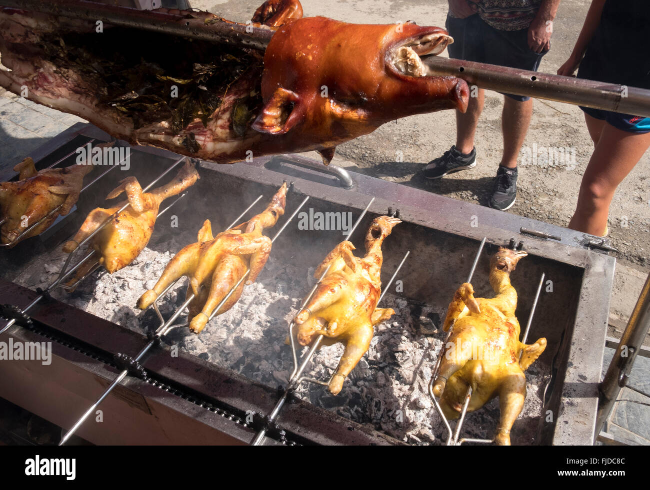 Un maiale e polli vengono arrostite su una rotisserie spit nel centro di Sapa, Vietnam Foto Stock