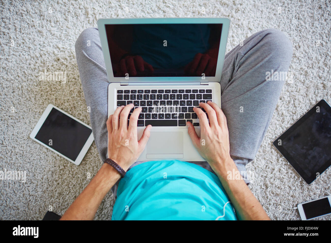 Il Multitasking uomo laptop utilizzando la connessione wi-fi Foto Stock