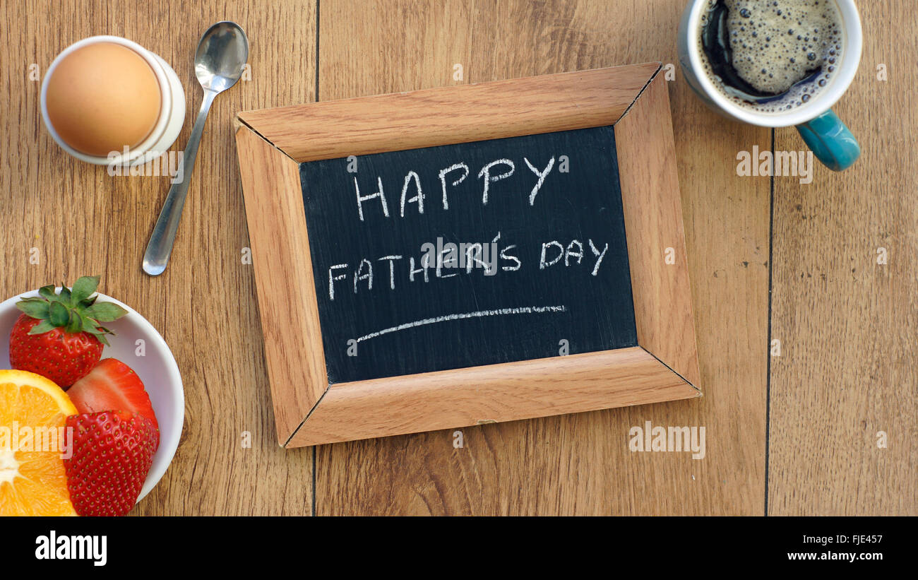 Felice Festa del papà scritto su una lavagna tra una prima colazione per lui Foto Stock