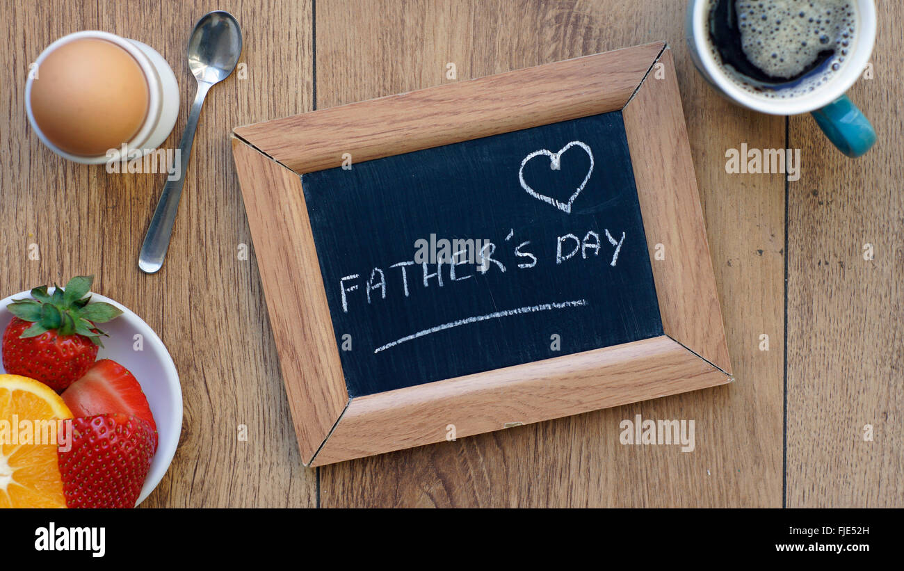 La festa del papà scritto su una lavagna tra una prima colazione per lui Foto Stock