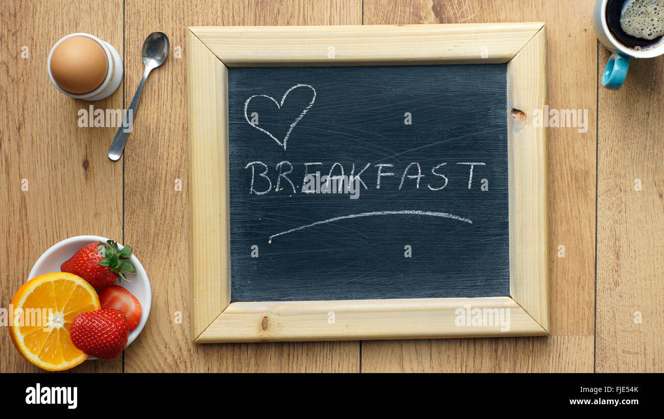 Amore prima colazione scritto su una lavagna Foto Stock