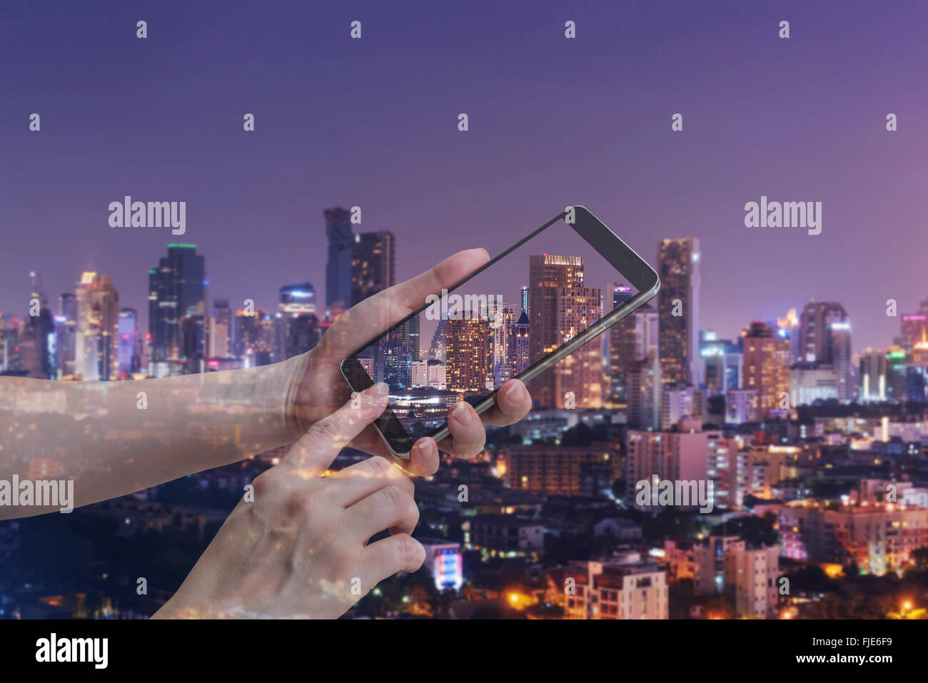 La doppia esposizione femminile di tenere in mano e il touch screen smart phone, tablet,cellulare su city night sfondo luminoso. Foto Stock