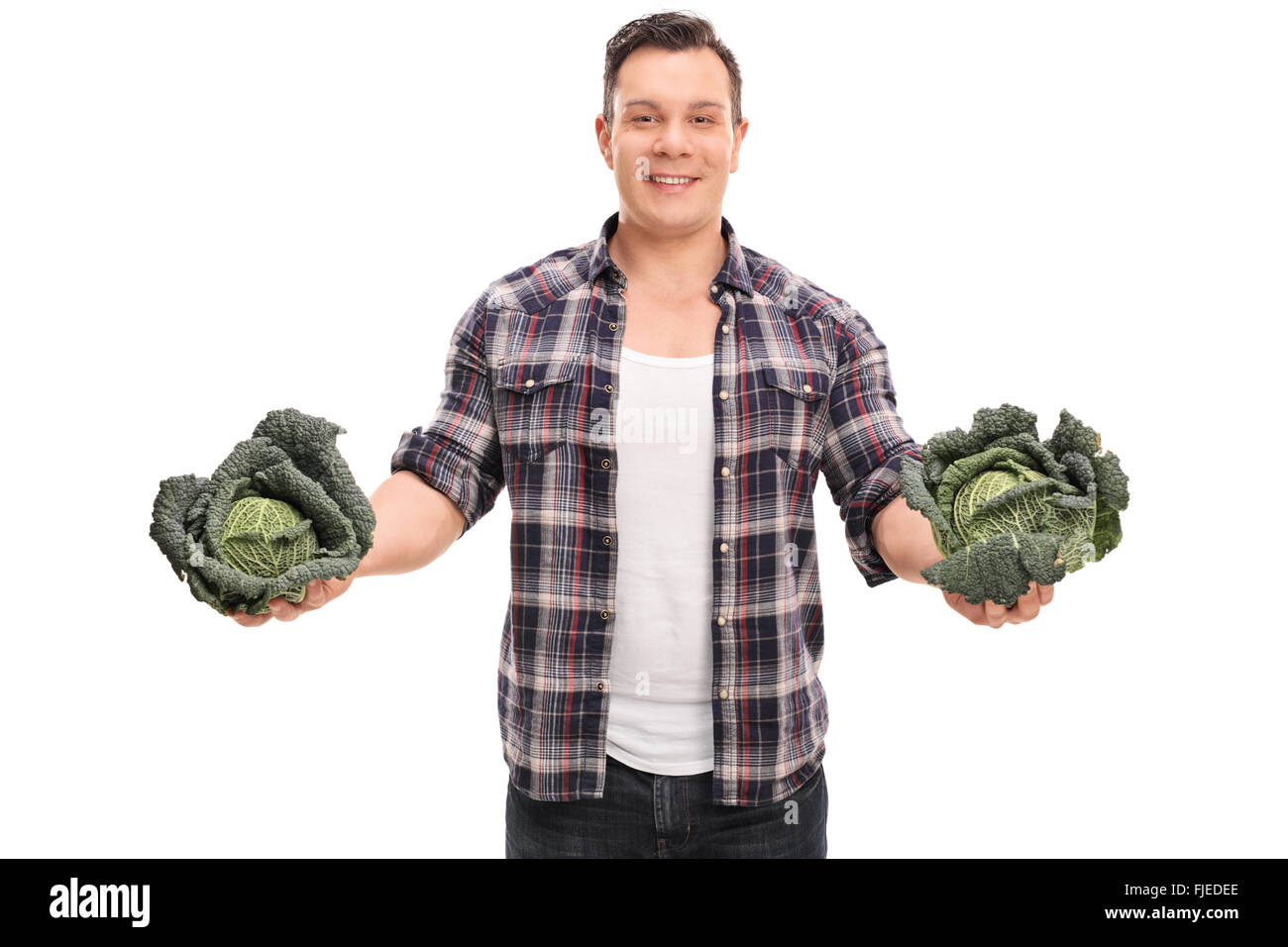 Studio shot di un giovane agricoltore che detiene due interi Savoy cavoli cappucci isolati su sfondo bianco Foto Stock