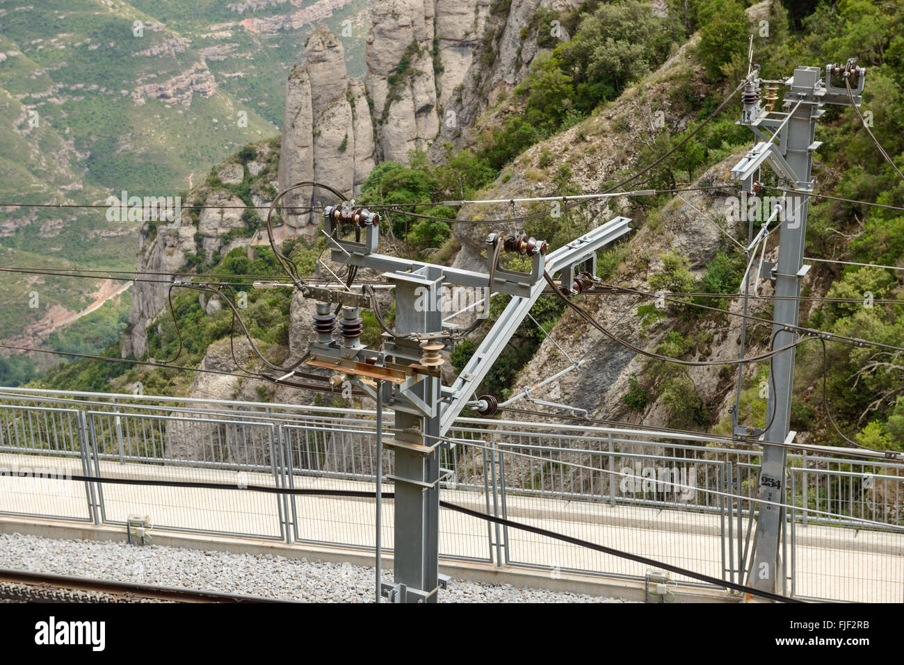 Alta Vista di angolo di contatto ferroviaria linea su sfondo di montagna di Montserrat abbazia nei pressi di Barcellona, in Catalogna, Spagna. Foto Stock