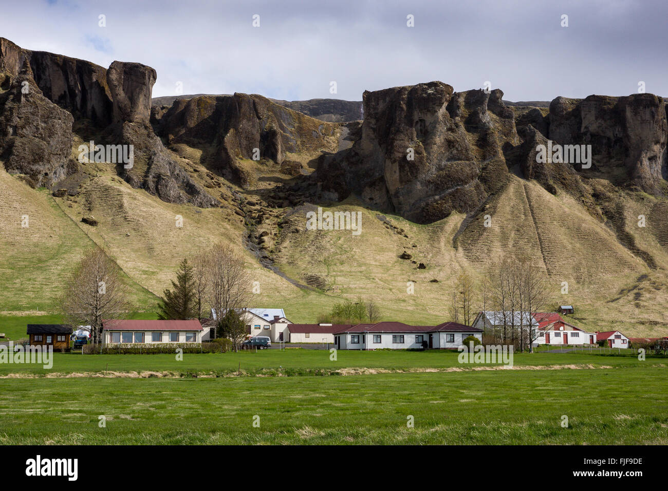Montagne vulcaniche dell'Islanda con fattoria alla base, vicino a Foss a sidu Foto Stock