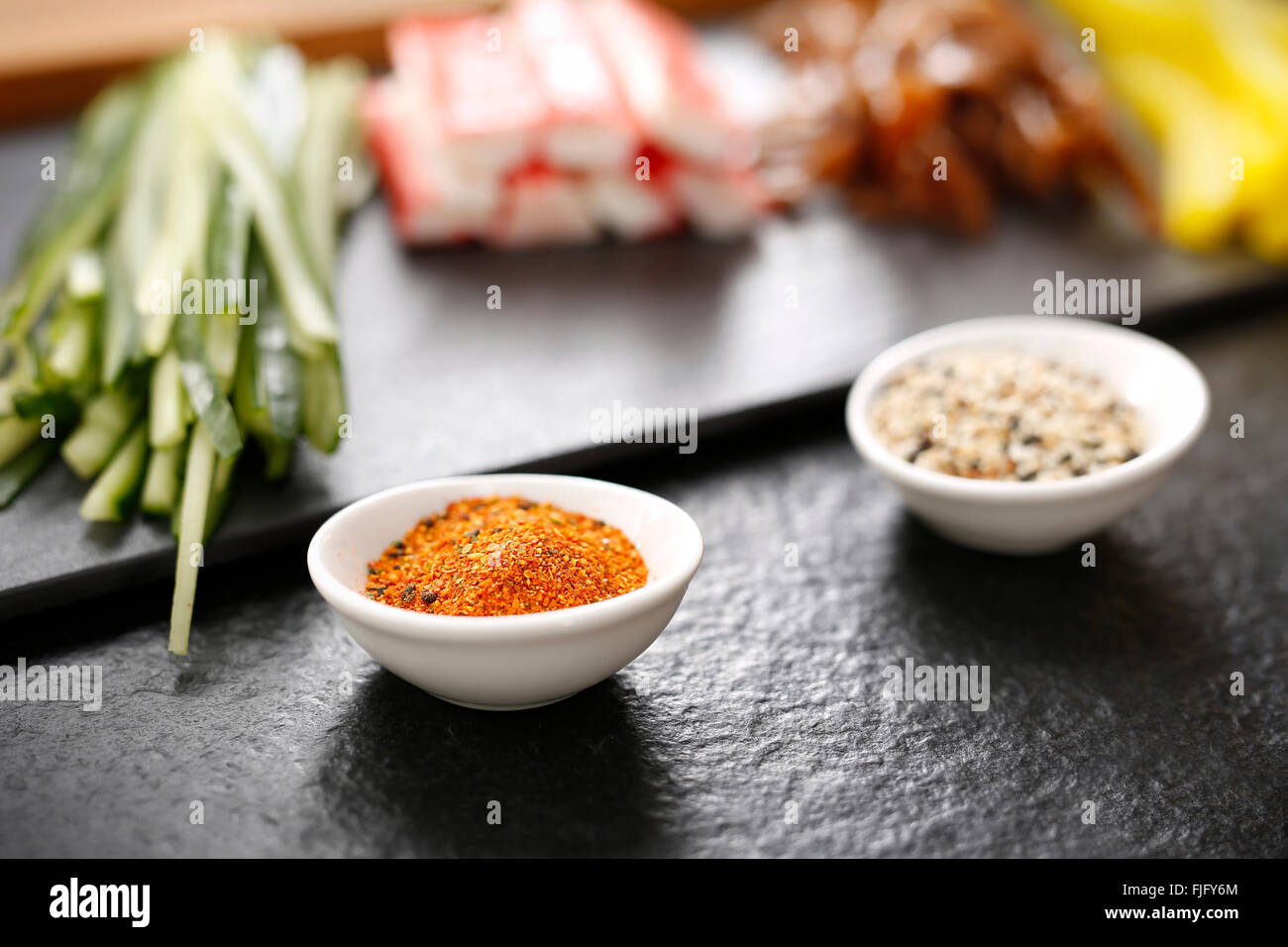Sushi fasi di preparazione di sushi con salmone, granchio dito, cetriolo zucca avvolto in nori alghe. Foto Stock