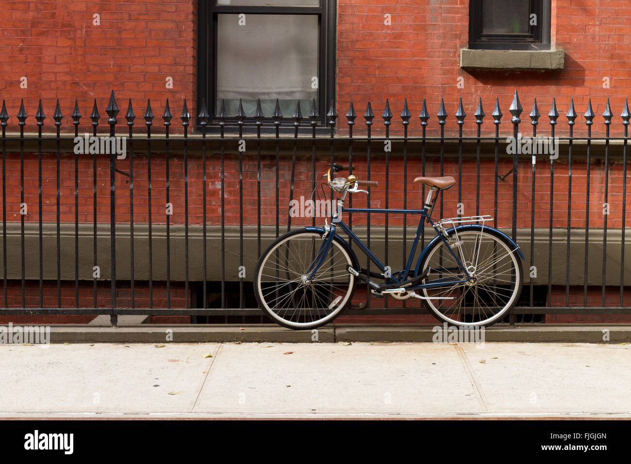Bicicletta parcheggiata su una strada urbana a NYC Foto Stock