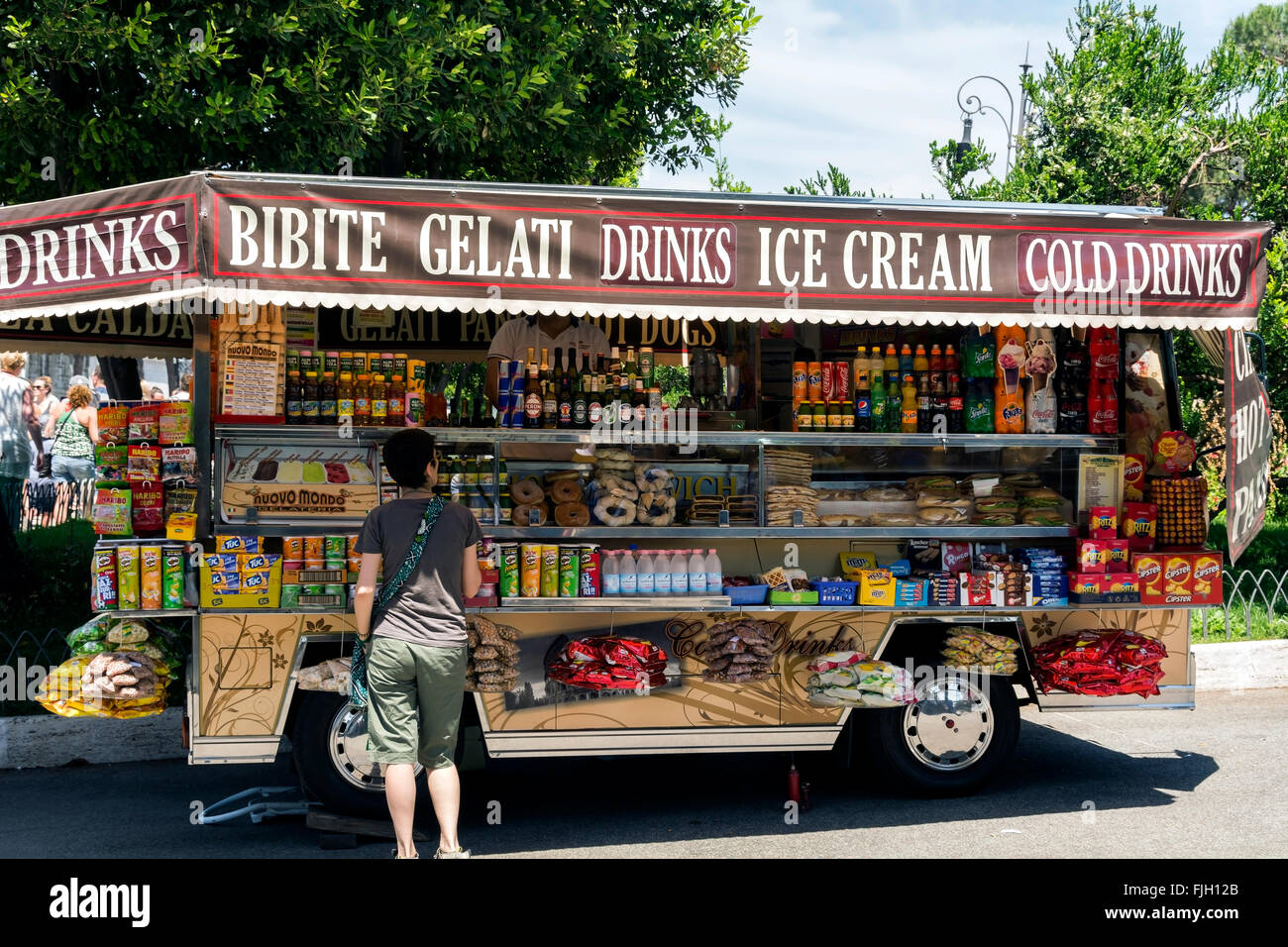 Una donna comprare snack / drink da un chiosco mobile. Foto Stock