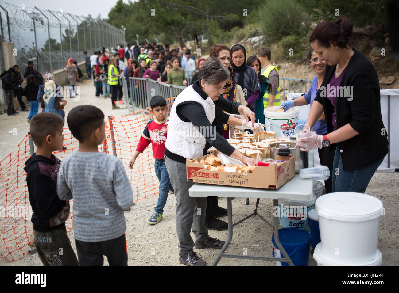 Samos, Grecia. 2 Mar, 2016. I rifugiati in attesa per un pranzo caldo al di fuori di un Rifugiato a centro di accoglienza in Vathi sull isola di Samos, Grecia, 2 marzo 2016. Per mesi una squadra di 8 persone residenti dell'isola è stata fornendo il pranzo per i rifugiati ogni giorno. Essi pagare per il cibo dalle proprie tasche e con donazioni, rendendo in media circa 1000 porzioni al giorno. Foto: CHRISTIAN CHARISIUS/DPA/Alamy Live News Foto Stock