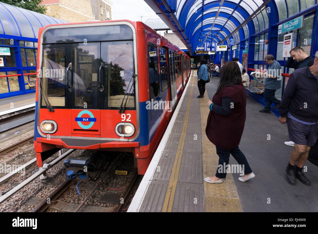 Treni DLR tirando a prua stazione Chiesa nell'East End di Londra, Regno Unito. La Docklands Light Railway è un sistema automatizzato di metropolitana leggera di sistema aperto nel 1987 per servire raggiunge la Dockland area di Londra. Foto Stock