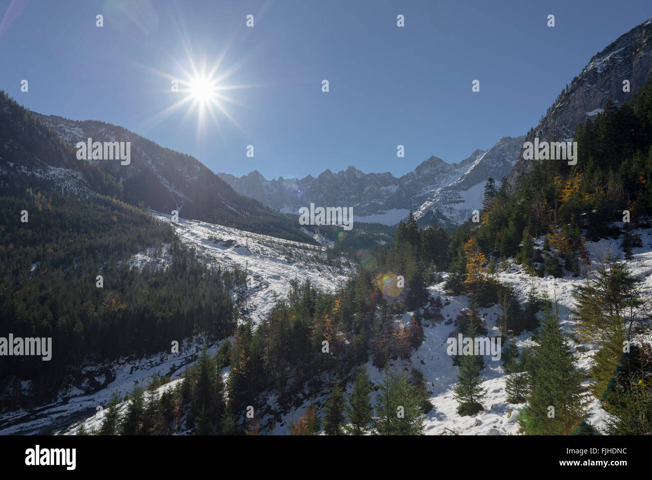 Il sole splende sulla neve-coperta di foreste di autunno nella valle di Johannes in montagne Karwendel, Tirolo, Austria Foto Stock