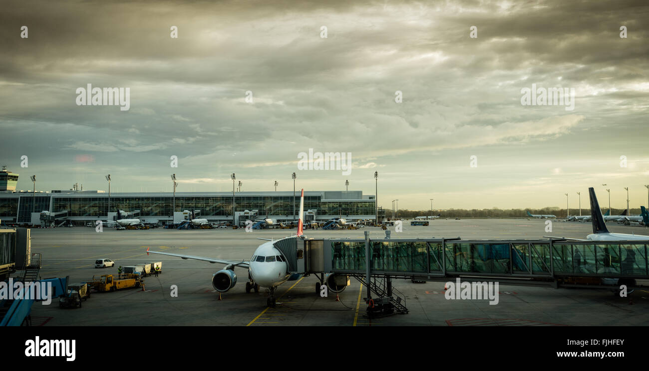 Aereo passeggeri con ponte di imbarco in aeroporto gate, immagine filtrata Foto Stock