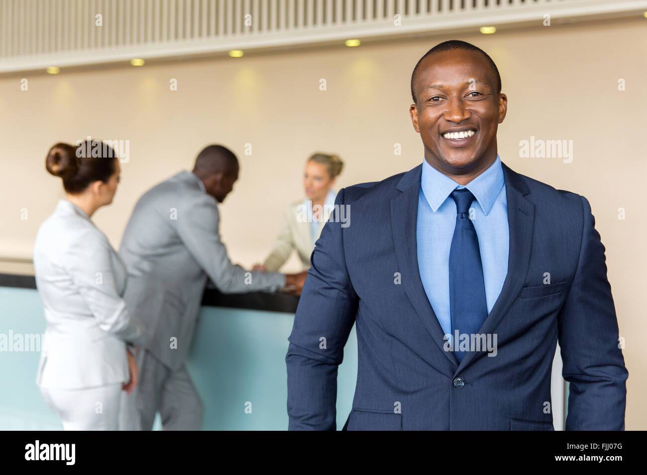 Ritratto di happy businessman africani in piedi presso la reception dell'hotel Foto Stock