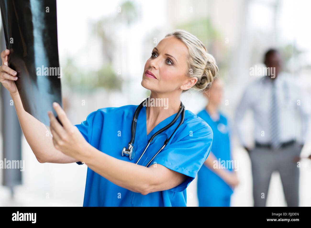 Riflessivo medico guardando al paziente la pellicola a raggi x Foto Stock