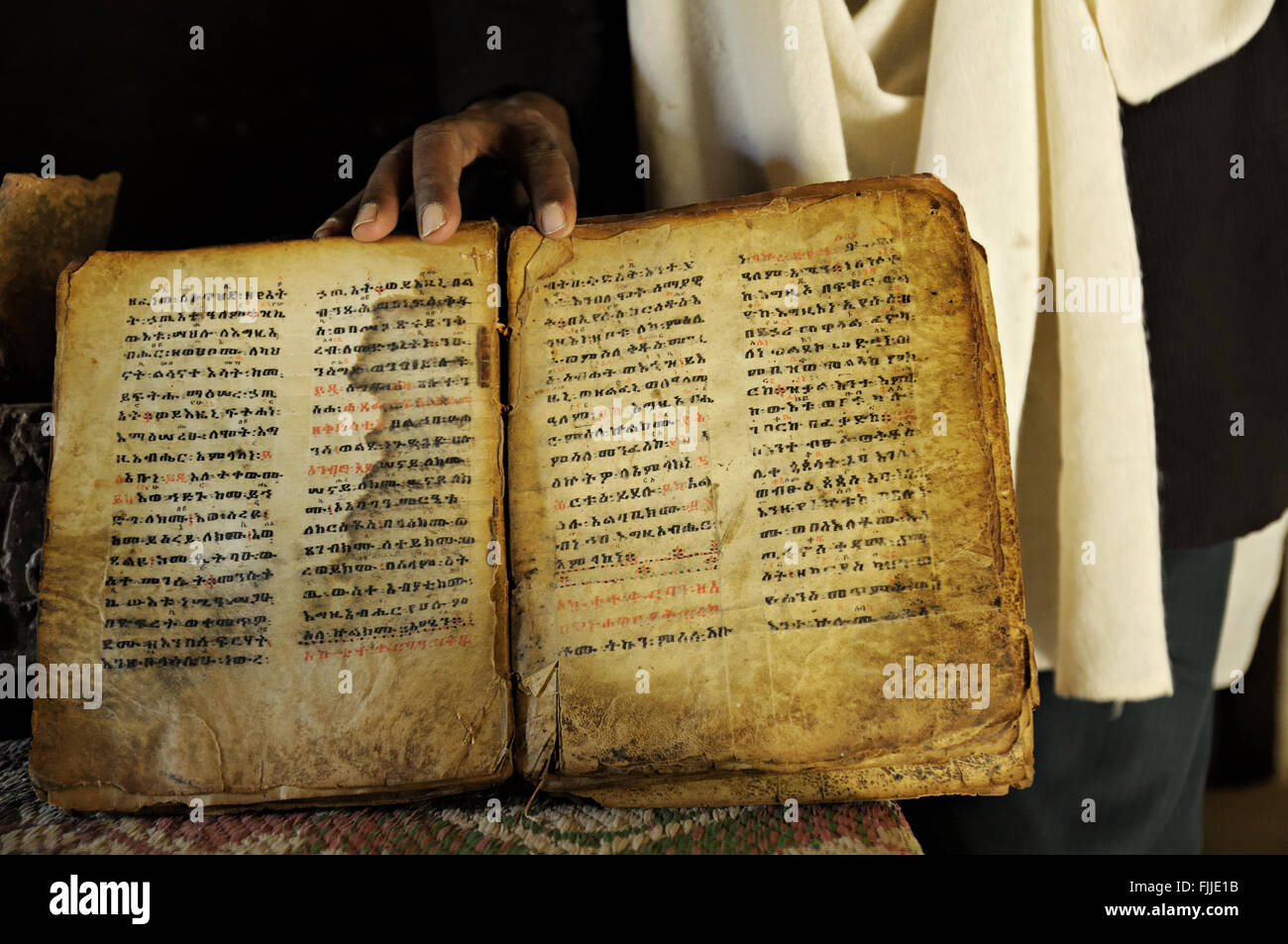 Un sacerdote ortodosso che mostra un antico manoscritto di pelle di capra che si trova sul sito di Yeha, Tigray, Etiopia Foto Stock
