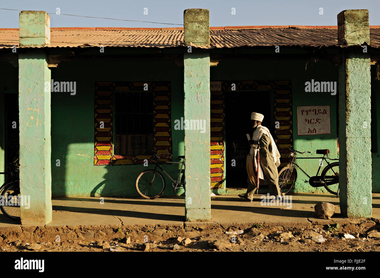 Età etiope uomo a camminare in un vicolo coperto in Axum (o Aksum), Tigray, Etiopia Foto Stock