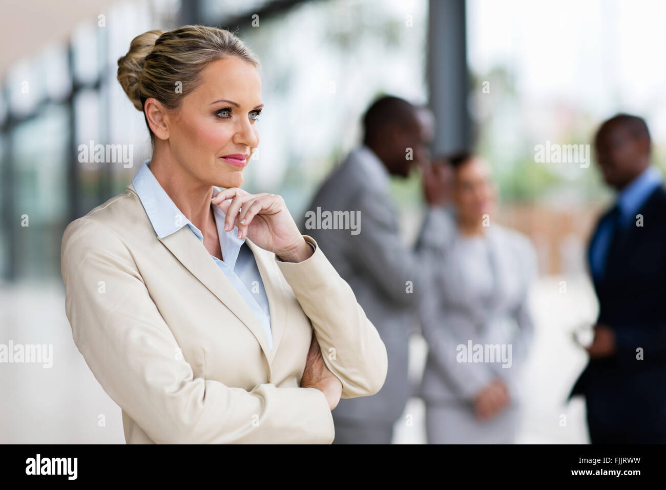 Riflessivo di mezza età imprenditrice in ufficio moderno Foto Stock