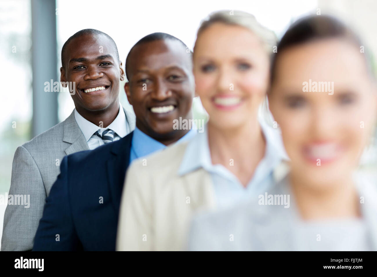 Gruppo di felice i dirigenti aziendali in piedi in una riga Foto Stock