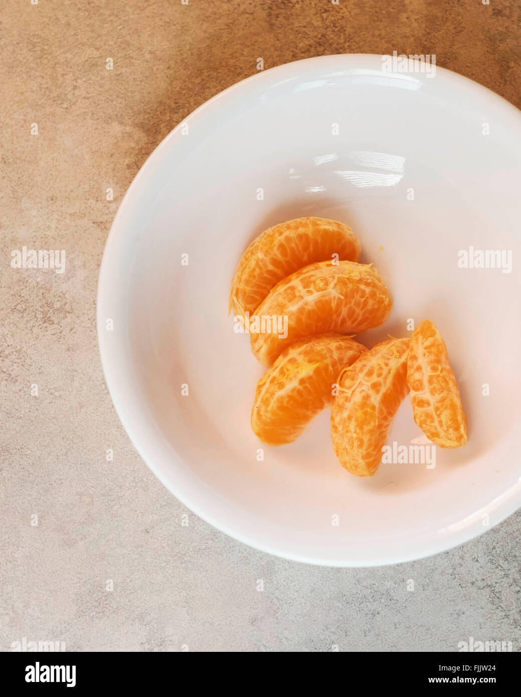 Mandarin fettine di arancia in una ciotola bianco dal di sopra. Foto Stock