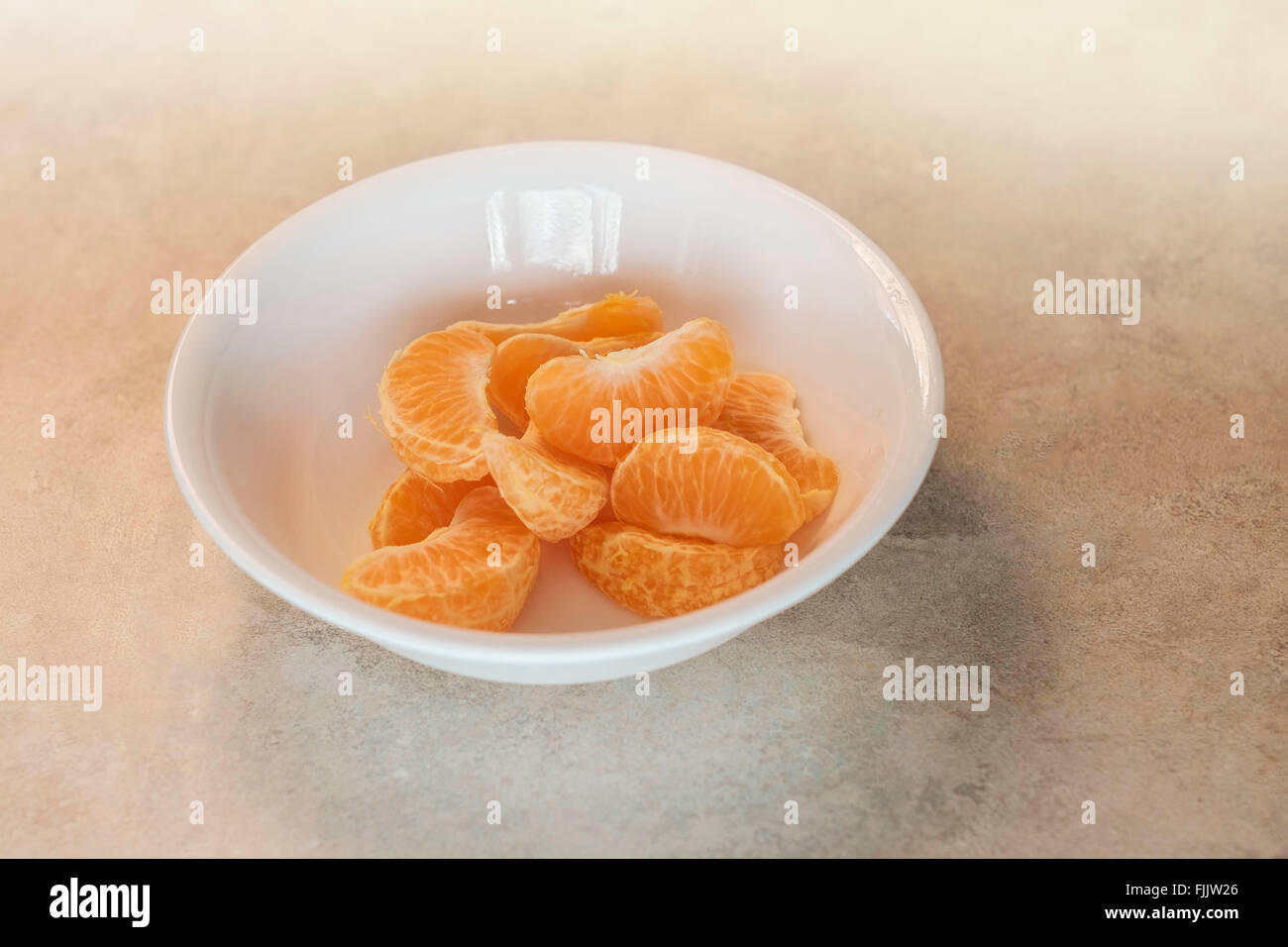 Arancio mandarino strati impilati in una ciotola bianco. Foto Stock