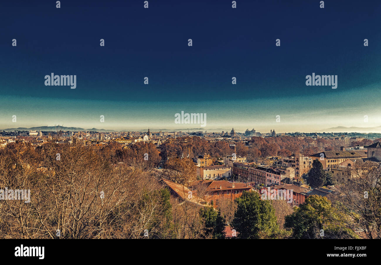 Vista che si affaccia sui tetti di Roma, antichi monumenti, palazzi storici, antichi edifici, chiese cattoliche e le vecchie case, verdi alberi e foglie di colore arancione Foto Stock