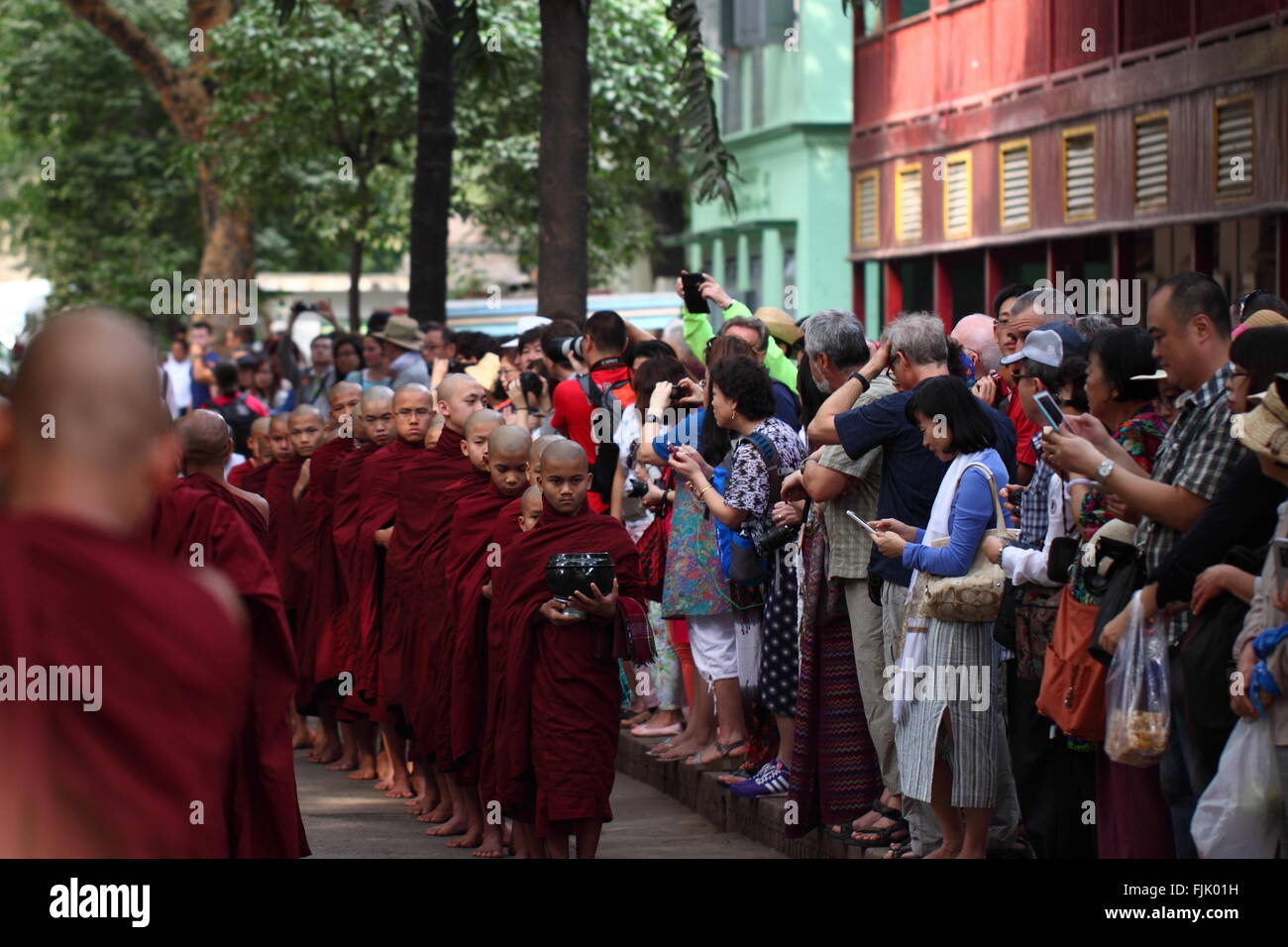Alms tradizionale cerimonia di consegna per la distribuzione di cibo ai monaci buddisti nelle strade di Mahar Gandar Yone Monastero , Myanmar Foto Stock