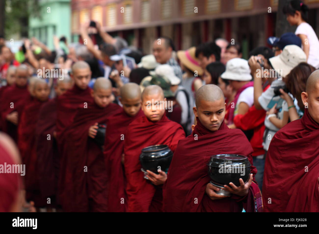 Alms tradizionale cerimonia di consegna per la distribuzione di cibo ai monaci buddisti nelle strade di Mahar Gandar Yone Monastero , Myanmar Foto Stock