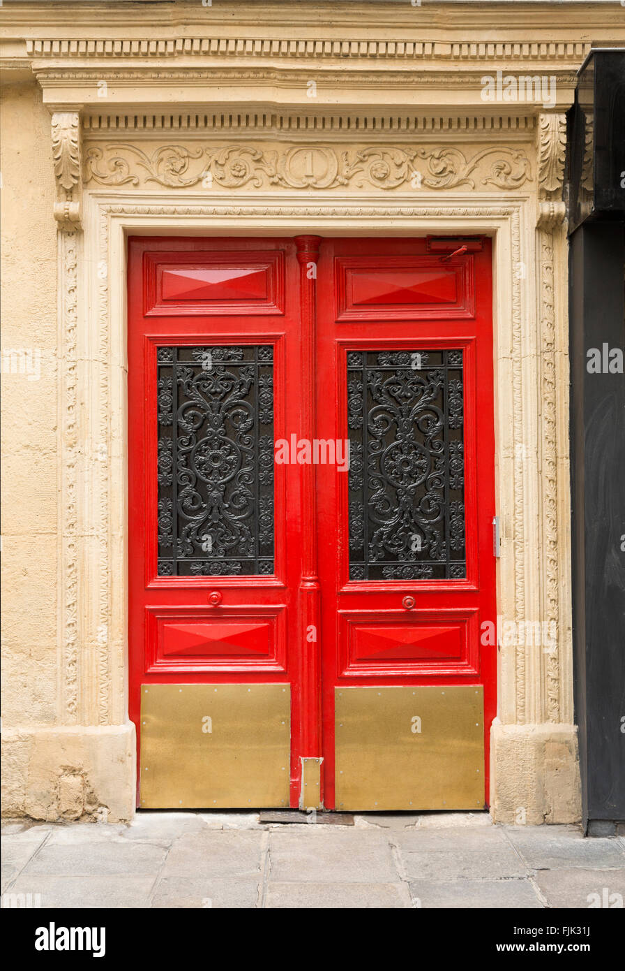 Tipico dettaglio architettonico di rosso le porte con il ferro battuto pannelli, Parigi, Francia Foto Stock