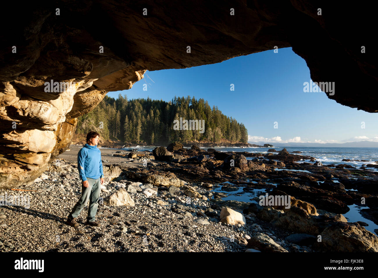Escursionista nella grotta sulla spiaggia Sombrio - Juan de Fuca Parco Provinciale, Isola di Vancouver, British Columbia, Canada Foto Stock