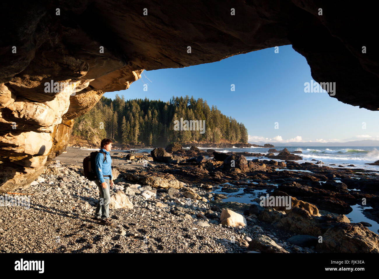 Escursionista nella grotta sulla spiaggia Sombrio - Juan de Fuca Parco Provinciale, Isola di Vancouver, British Columbia, Canada Foto Stock
