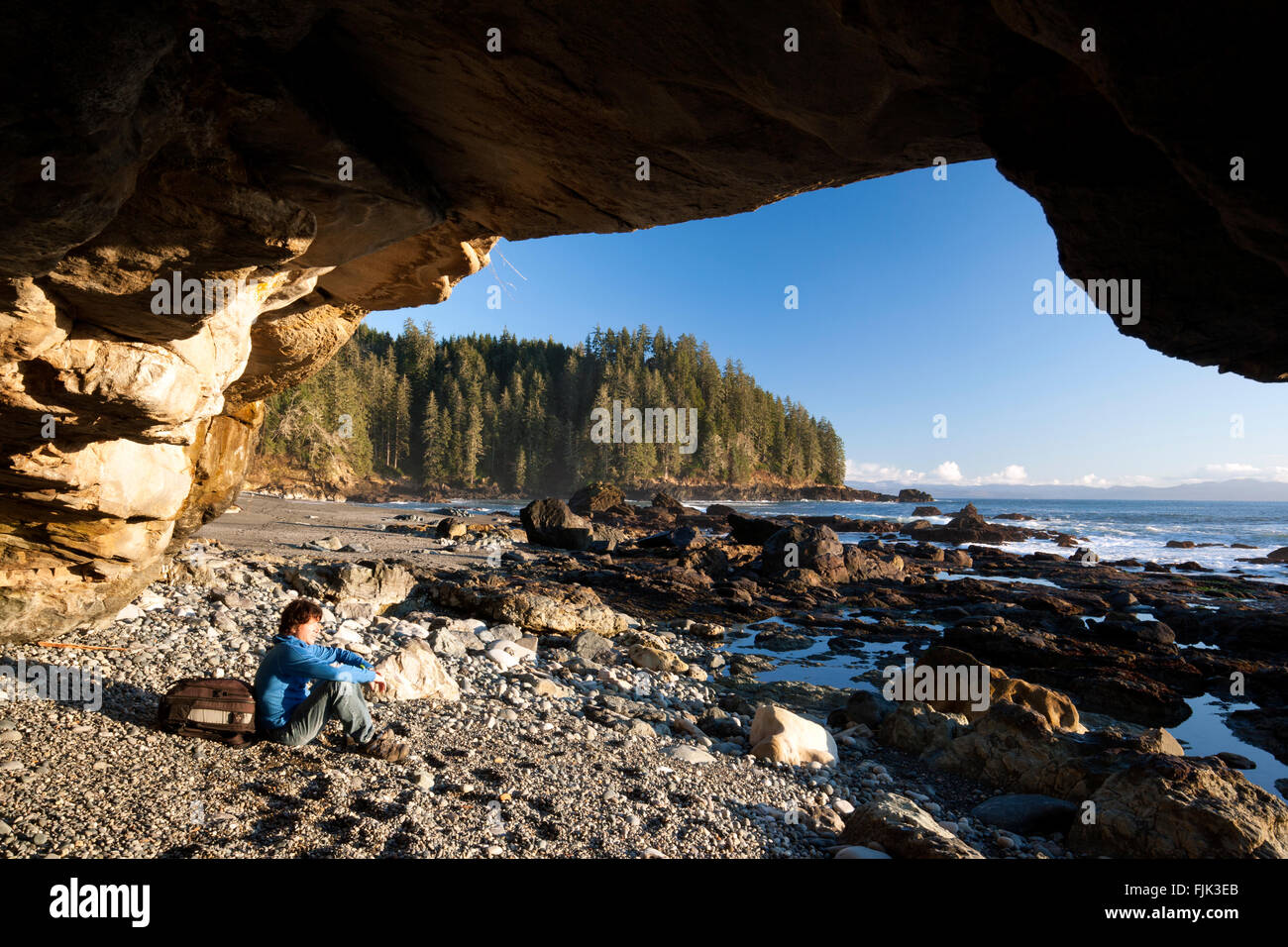 Escursionista nella grotta sulla spiaggia Sombrio - Juan de Fuca Parco Provinciale, Isola di Vancouver, British Columbia, Canada Foto Stock
